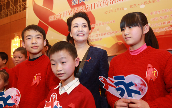 First lady, Peng Liyuan stands with children affected by HIV image credit: thechinawatch.com