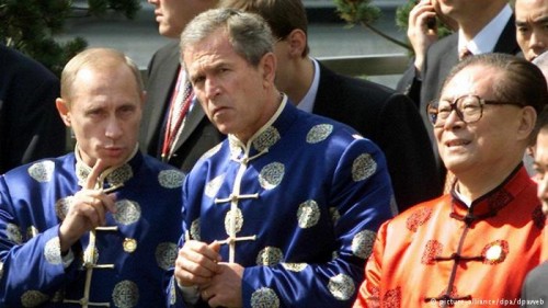 Presidents Vladimir Putin, George W. Bush, and Jiang Zemin wear silk jackets as a symbol of friendship during the 2001 APEC summit. Image credit: Picture alliance/ dpa/ dpaweb